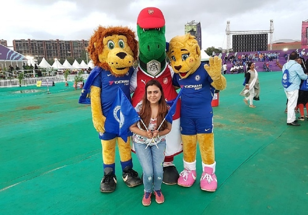 Visitors taking souvenir photographs with sports mascots on a festival ground