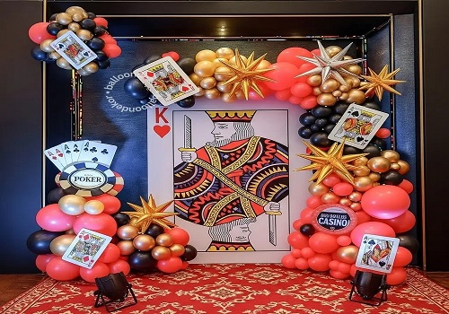 Casino theme party table with playing cards and chips under warm event lighting