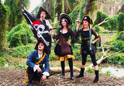 Pirate theme party backdrop with a ship and treasure chest props